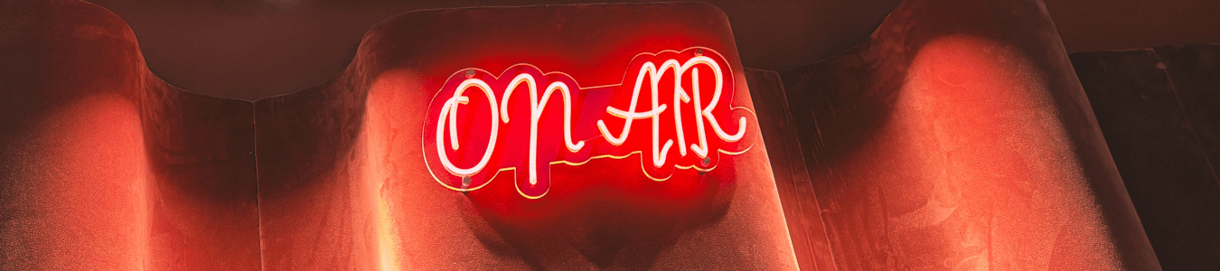 Podcast Live "on air" sign glowing red.