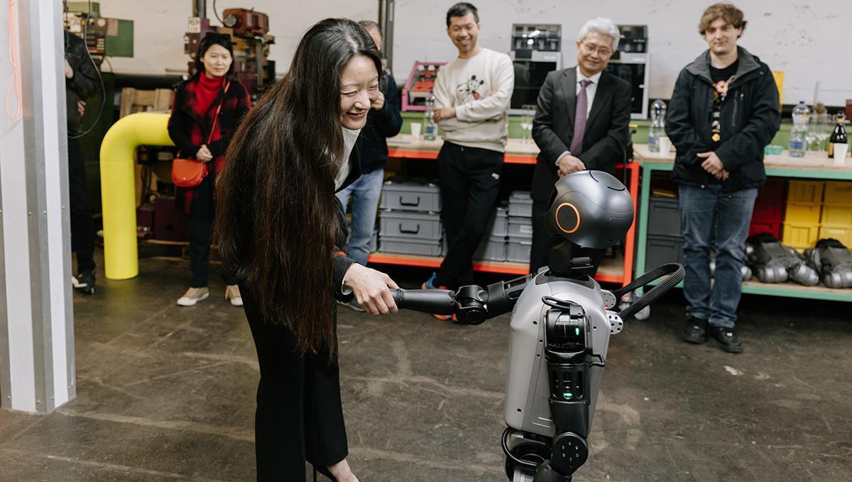 Yuan Martschnig Wei, Co-Founder and President of Creative AI Foundation CAIF, Yuan shaking a robots hand