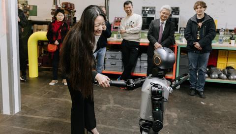 Yuan Martschnig Wei sharking hands with a robot at AATB Studio in Greater Zurich